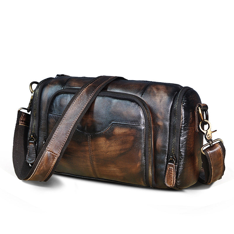 Brown leather duffel bag with a strap on a white background
