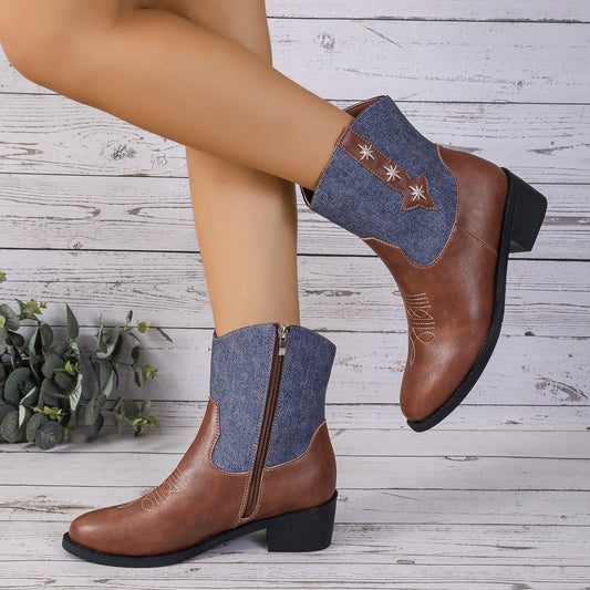 Brown ankle boots with denim patches on a wooden floor.
