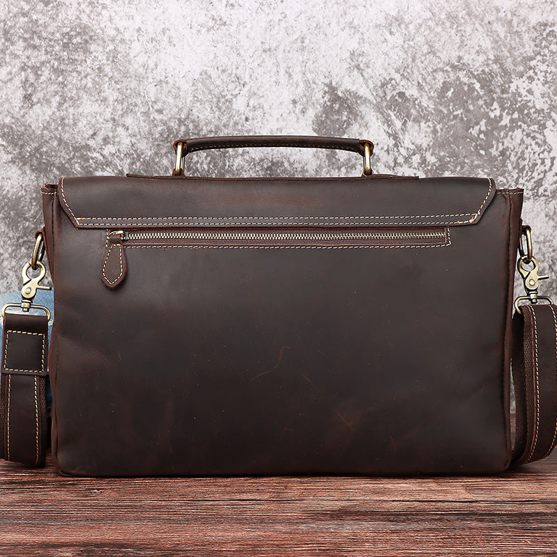 Brown leather briefcase on a wooden surface with a textured gray background