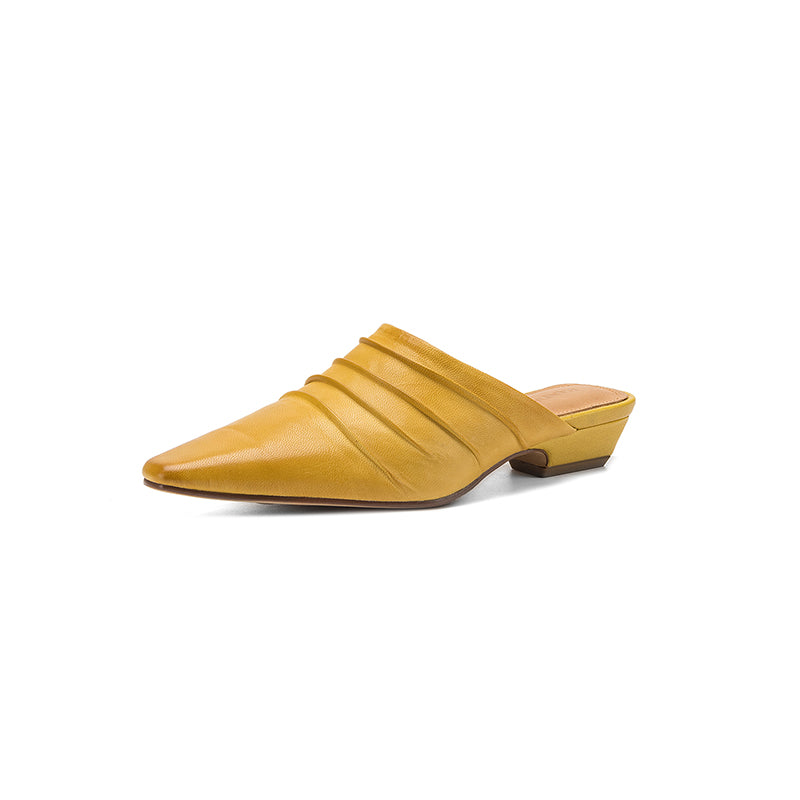 Yellow slip-on shoe with a pointed toe on a white background