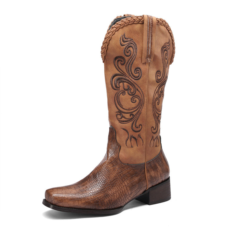 Brown cowboy boot with intricate embossing on a white background