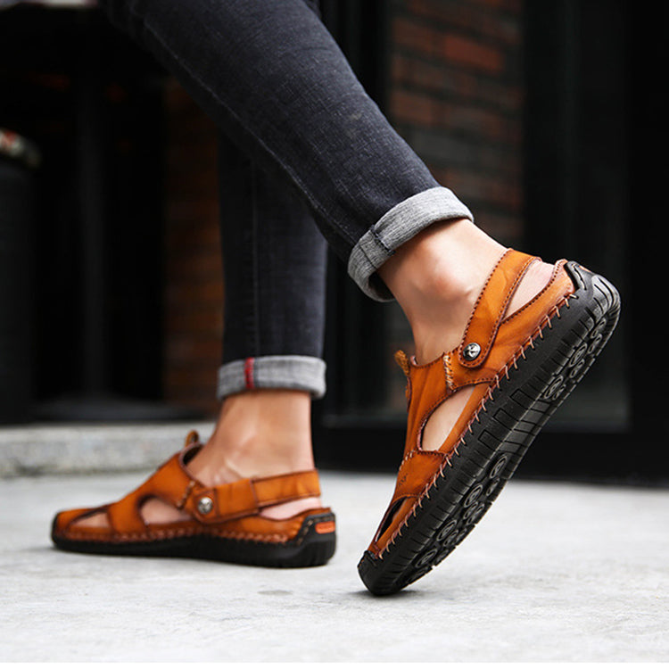 Brown sandals worn with rolled-up jeans on a blurred background