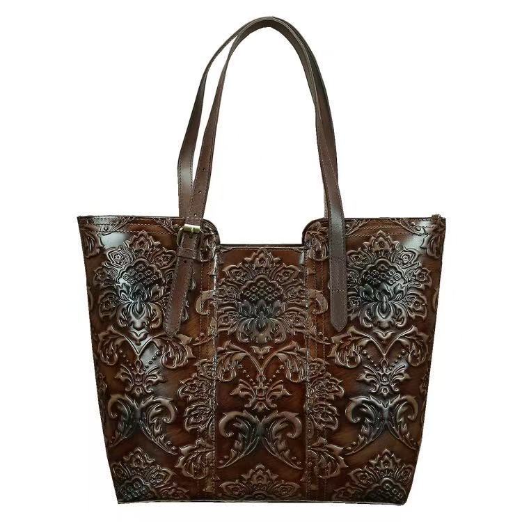 Brown leather tote bag with intricate embossed design on a white background