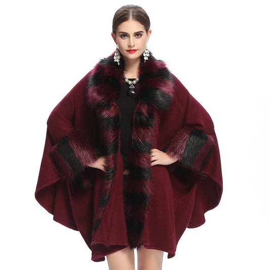 Woman wearing a burgundy cape with black fur trim on a white background