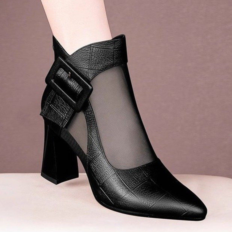 Black ankle boot with mesh design and buckle detail on a neutral background