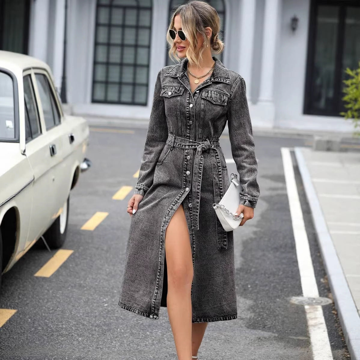Woman wearing a denim dress with a car and building in the background