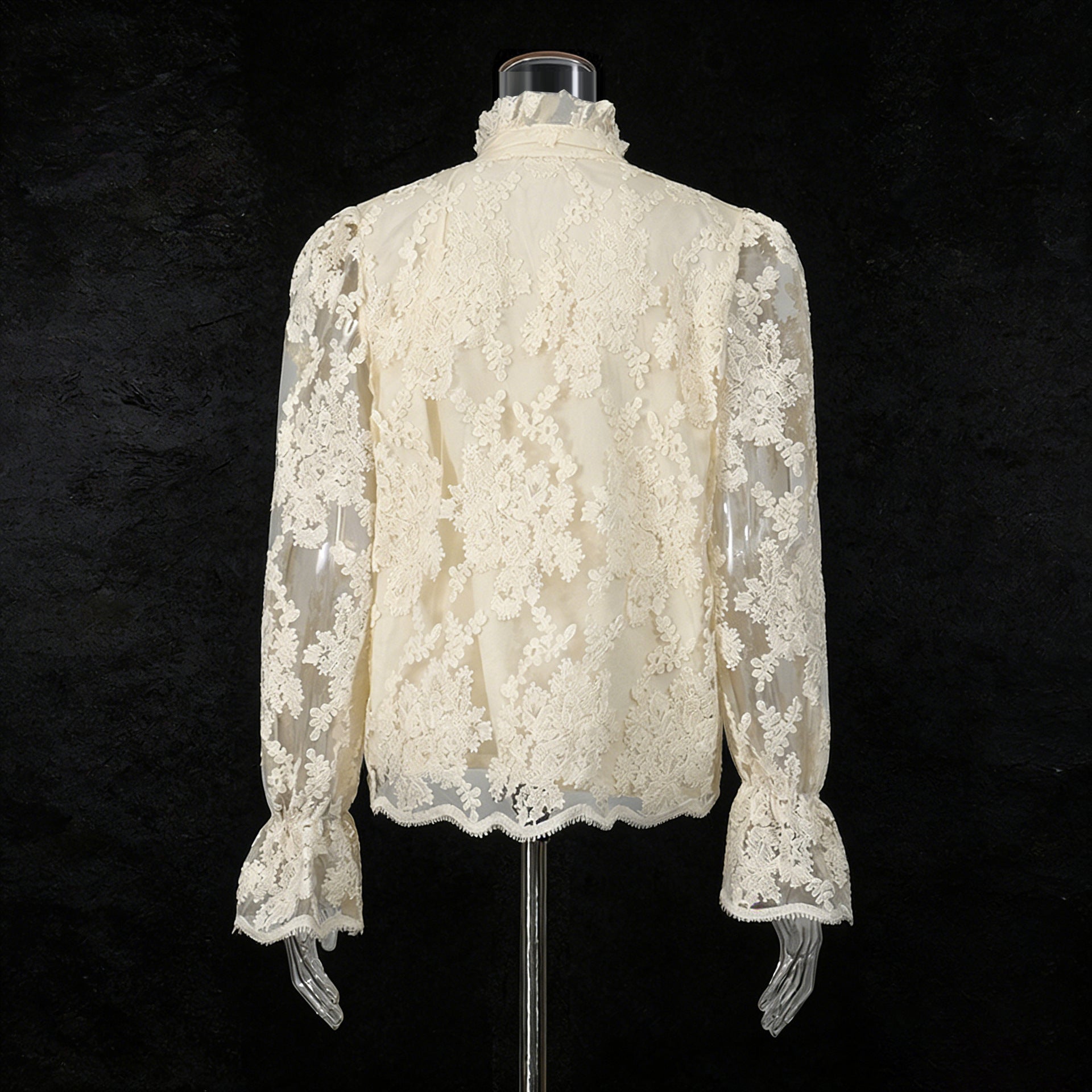 White lace blouse on a mannequin against a black background