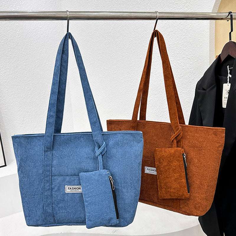Blue and brown tote bags with matching small pouches on a rack.