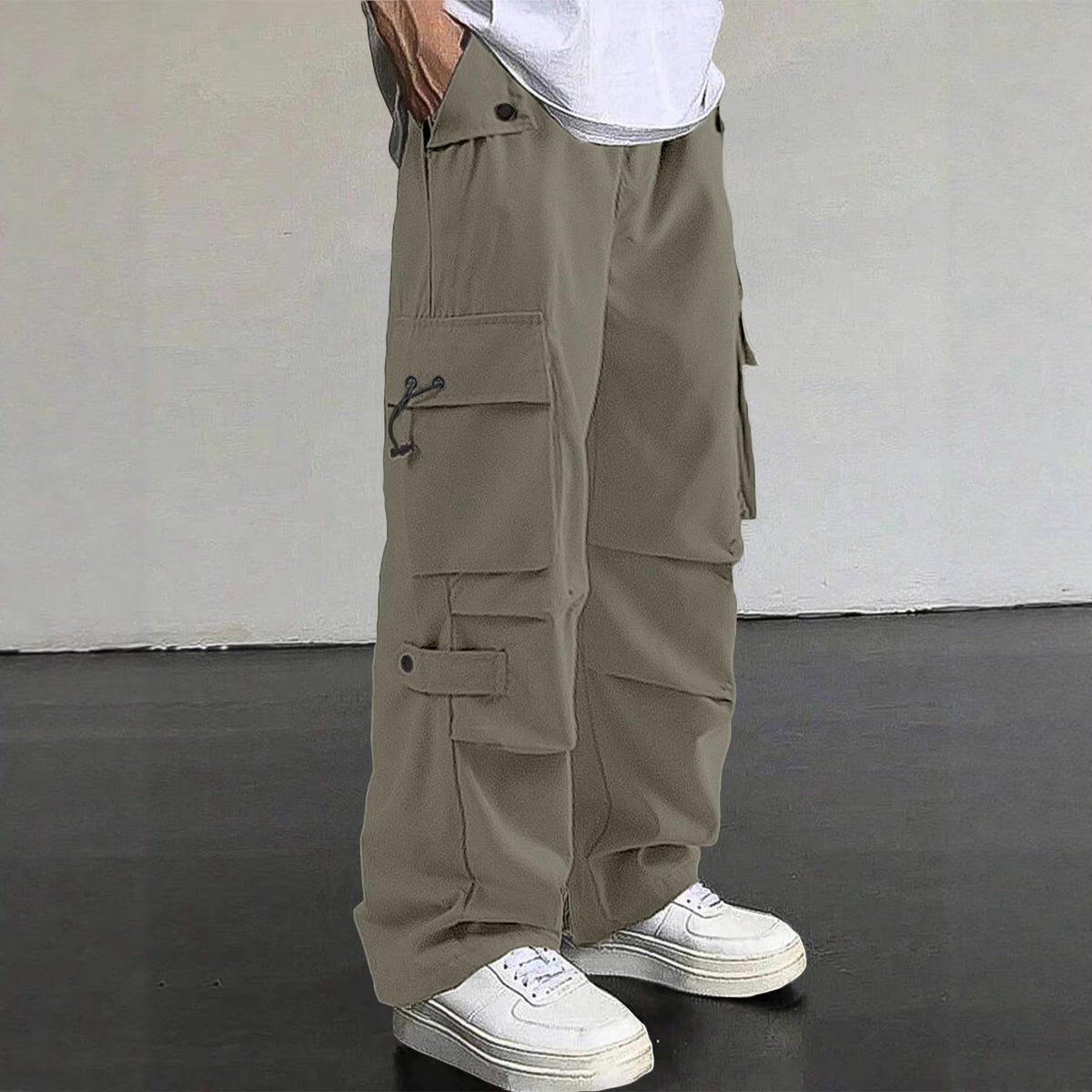 Person wearing beige cargo pants with a white background