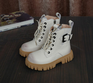 White boots with brown soles on a dark surface
