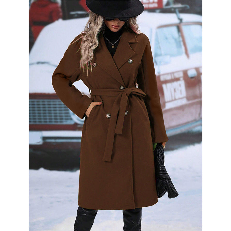 Woman wearing a brown coat with a vintage car in the background