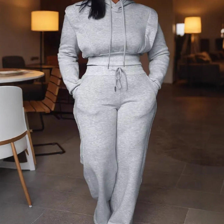 Person wearing a gray tracksuit in a room with lamps and furniture.