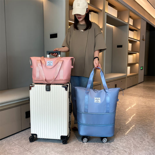 Person holding a pink bag and a blue suitcase in an indoor setting