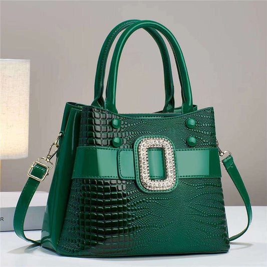 Green handbag with a decorative buckle on a neutral background