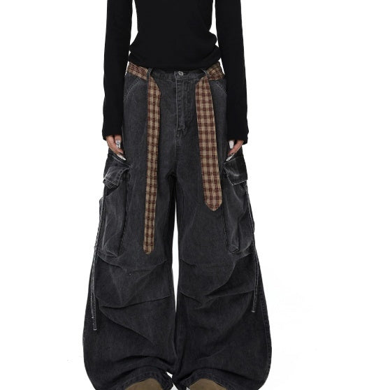 Dark gray wide-leg pants with plaid accents worn by a person on a white background