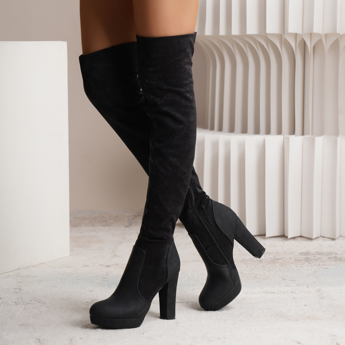 Black knee-high boots on a neutral background