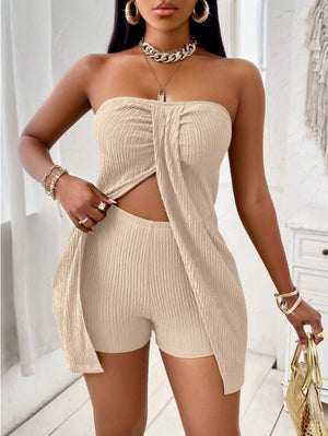 Woman wearing a beige strapless top and shorts set with gold accessories.