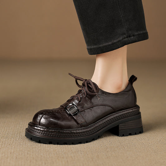 Brown leather shoes worn with black pants on a beige background
