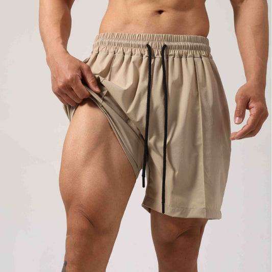 Beige shorts with black drawstrings on a plain background