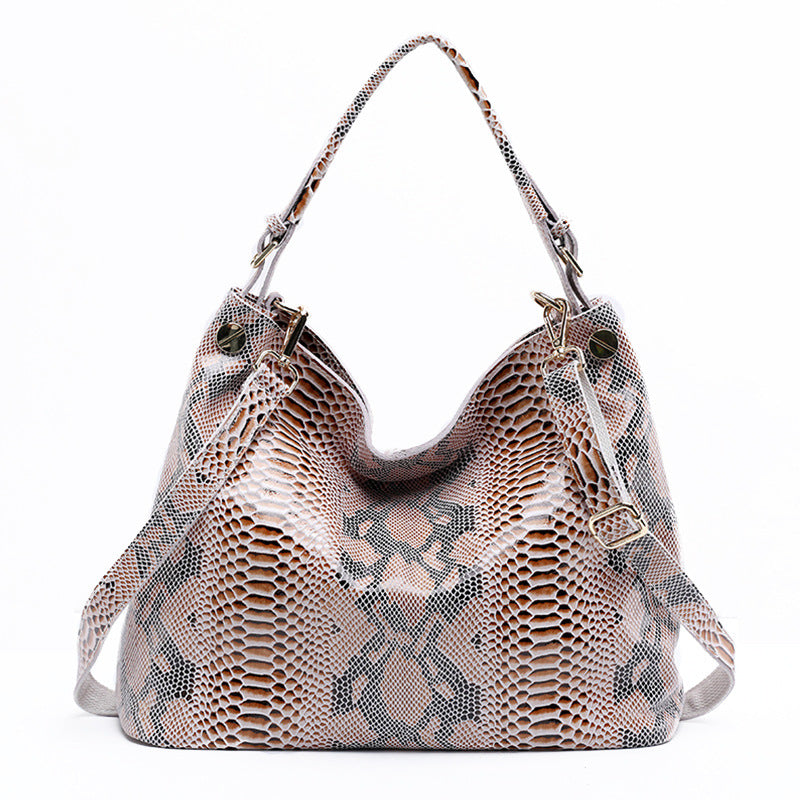 Designer handbag with snake skin pattern on a white background