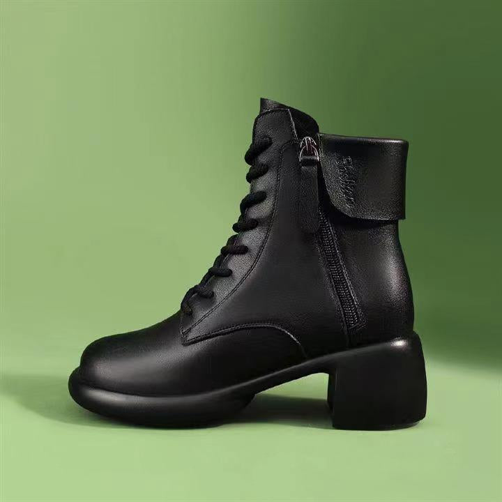 Black leather boot with a zipper on a green background