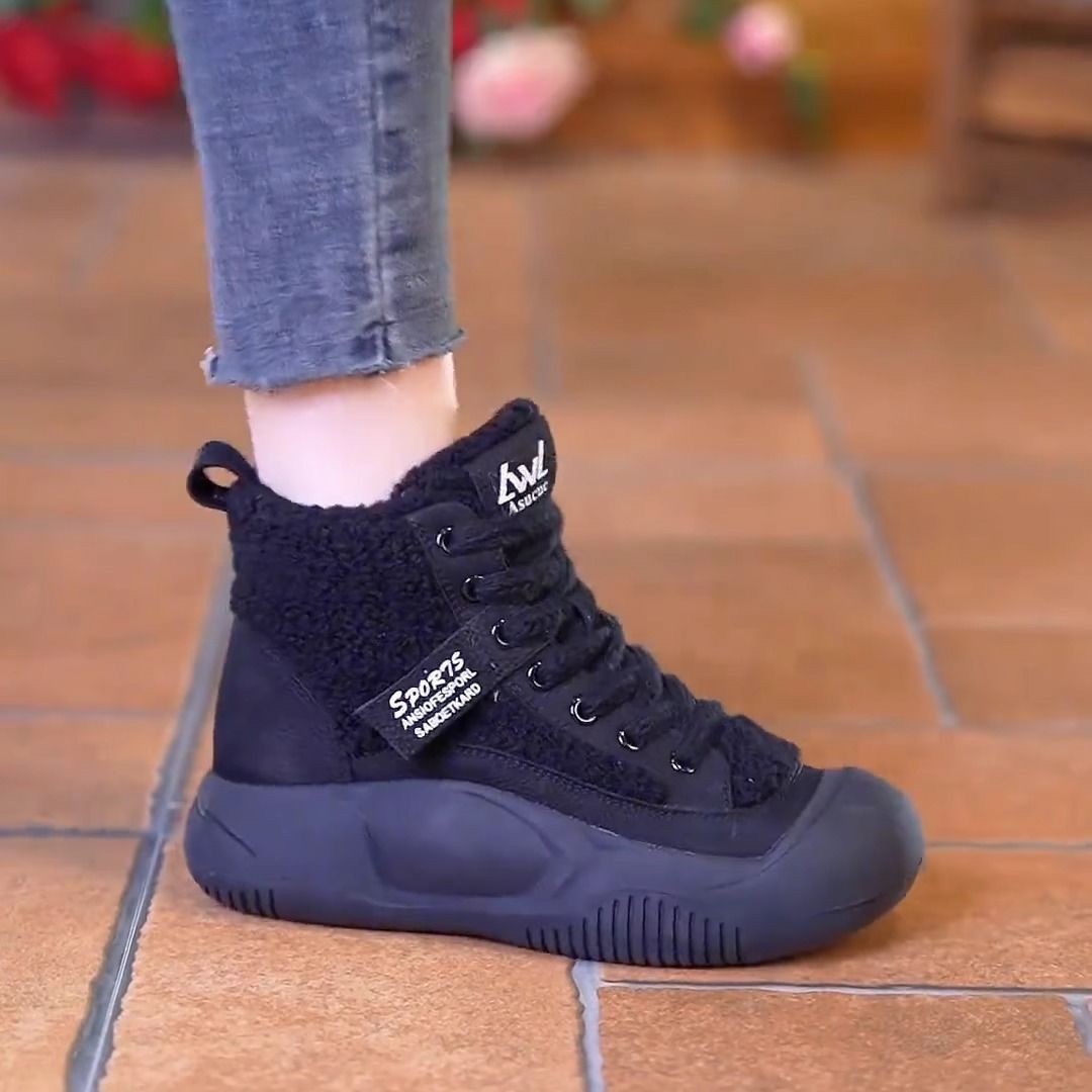 Black sneaker with brand logo worn on a tiled floor