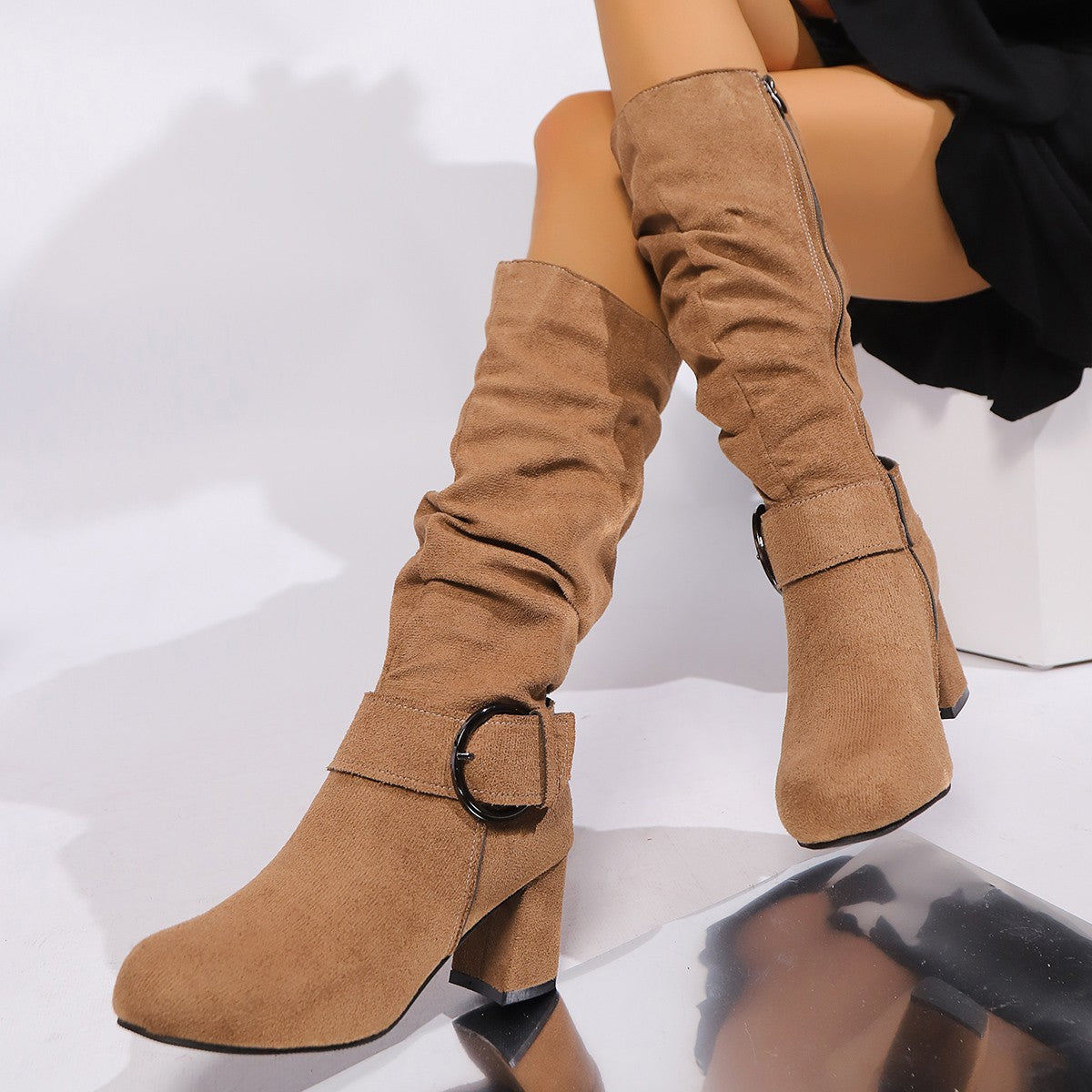 Brown suede knee-high boots with a buckle on a white background