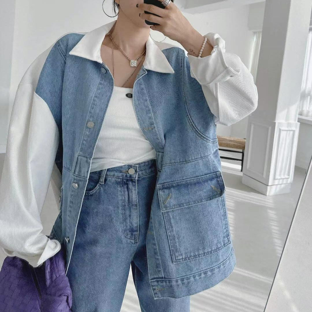Person wearing a denim vest over a white shirt in a minimal indoor setting