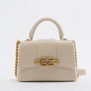 Beige handbag with gold chain detail on a white background