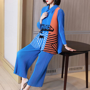 Woman in a blue and orange outfit sitting on a table indoors.