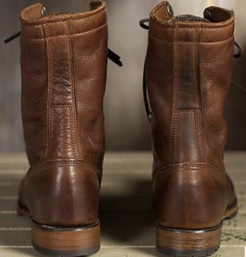 Pair of brown leather boots on a neutral background