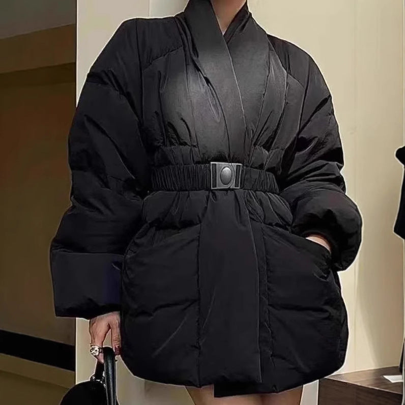 Person wearing a black puffer coat with a belt in an indoor setting
