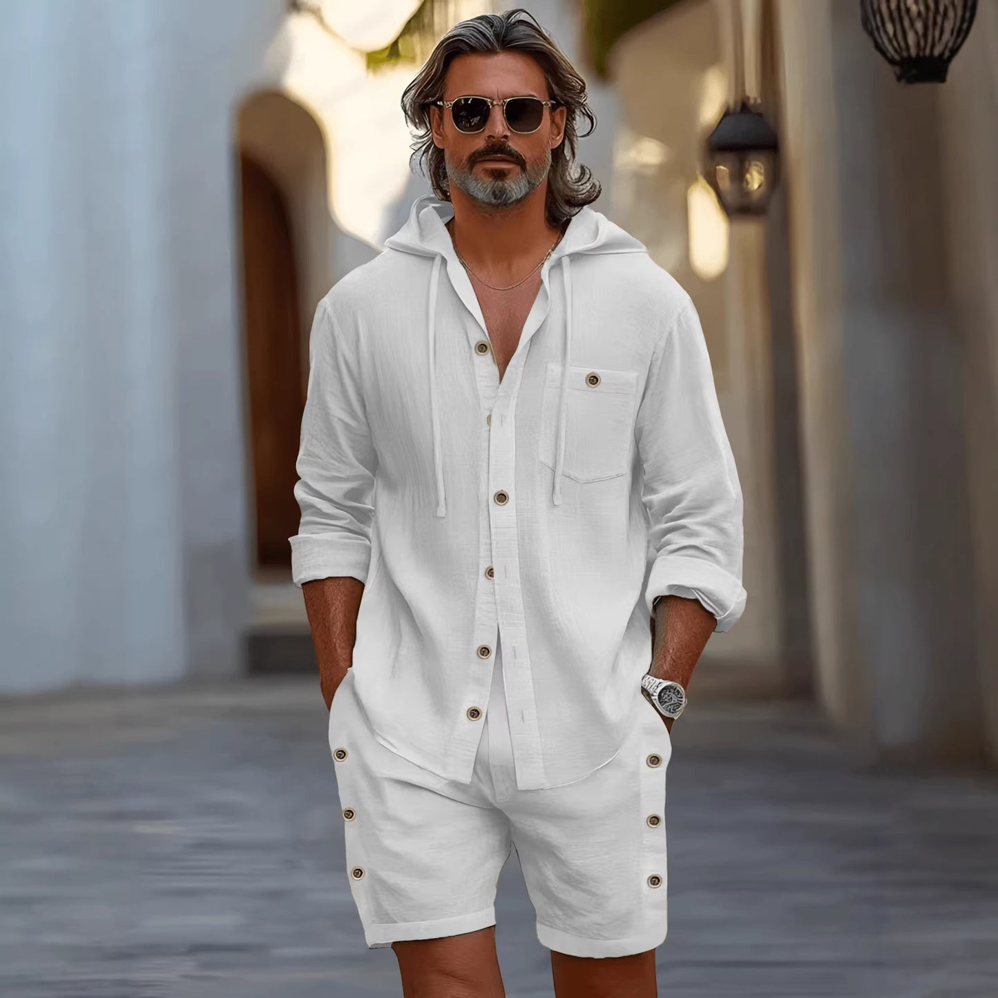 Man wearing a white outfit with sunglasses in an outdoor setting