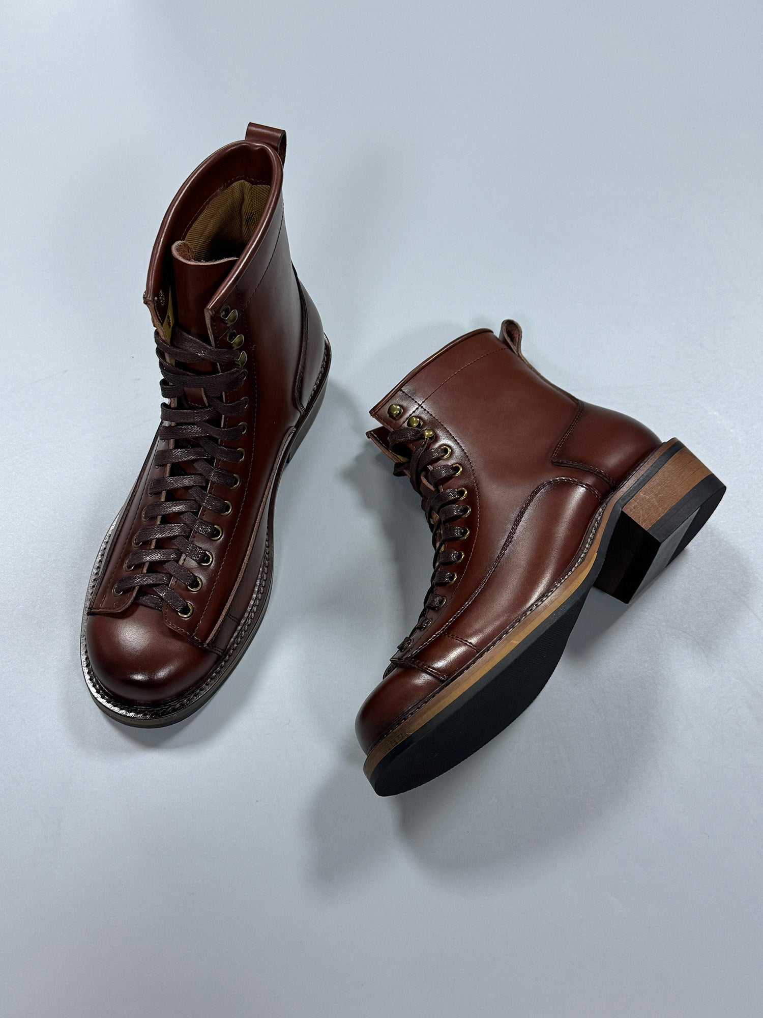 Pair of brown leather boots on a light gray background