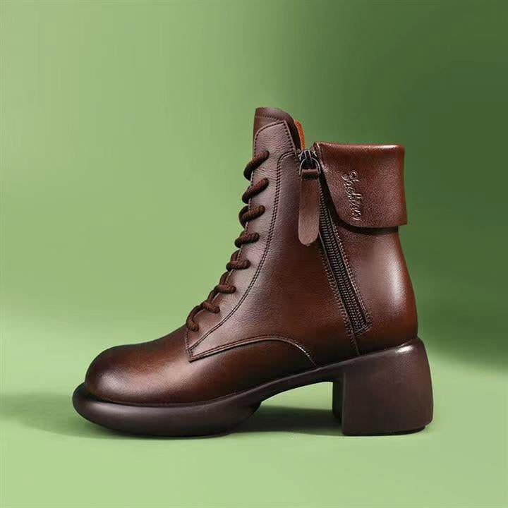 Brown leather boot with a zipper on a green background