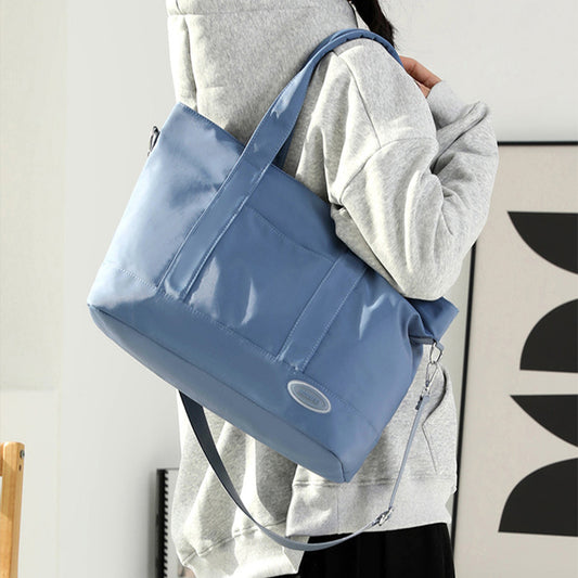 Person holding a blue bag against a neutral background