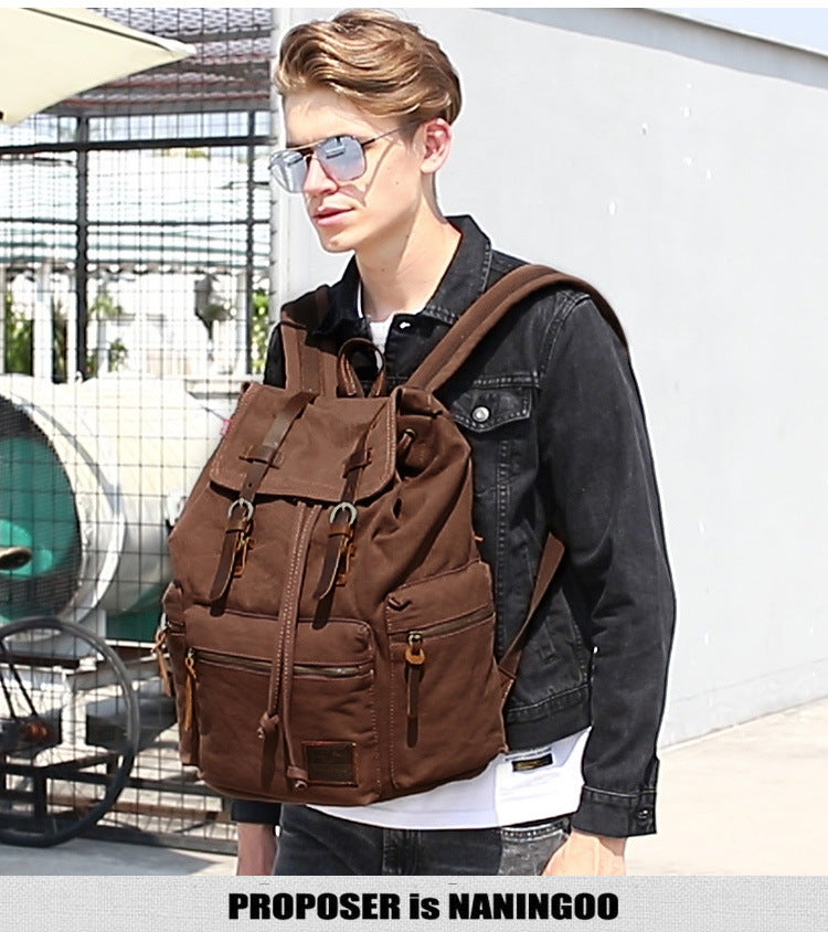 Man wearing a brown backpack outdoors with a blurred background
