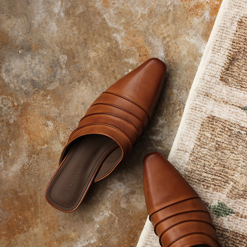 Pair of brown leather shoes on a textured stone surface