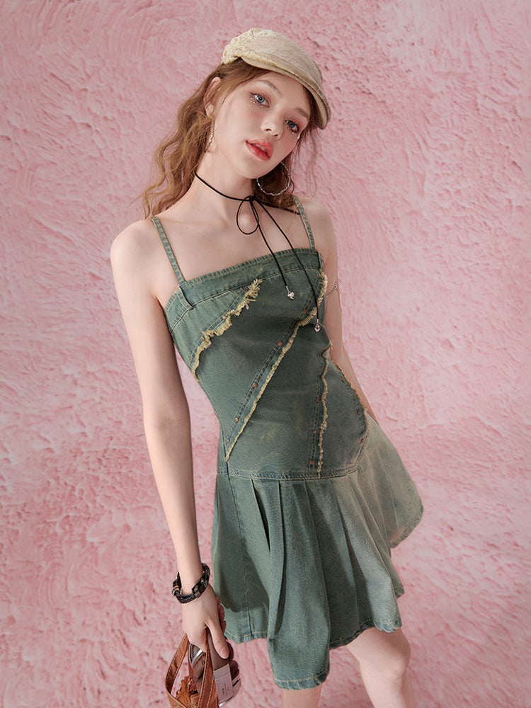 Woman wearing a green denim dress against a pink textured background