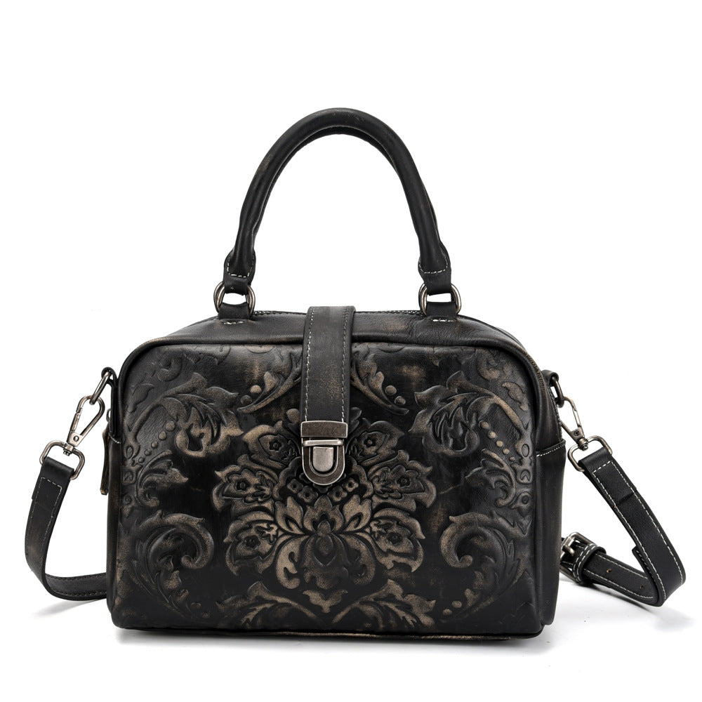 Black floral embossed handbag on a white background
