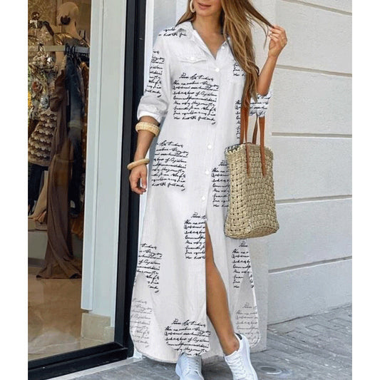 Woman wearing a white dress with black text pattern, holding a straw bag, standing in front of a store entrance.
