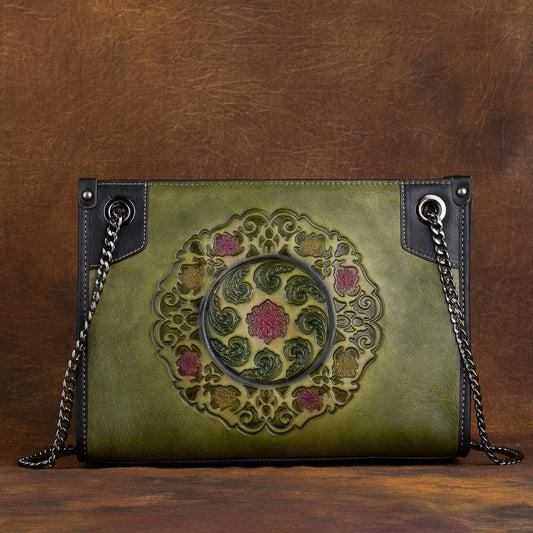 Green leather handbag with intricate design on a brown background