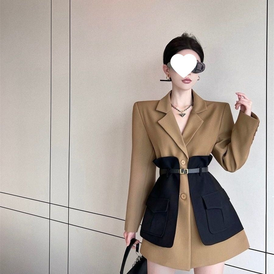 Woman wearing a two-tone coat with a neutral background