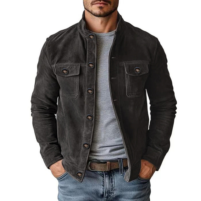 Man wearing a dark denim jacket over a gray shirt on a white background