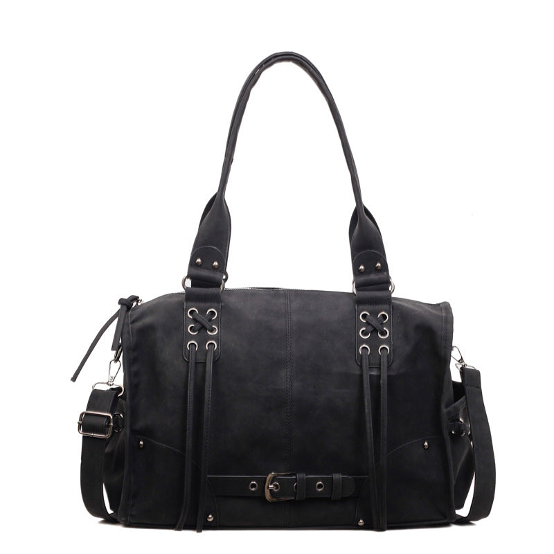 Black leather handbag with multiple straps on a white background
