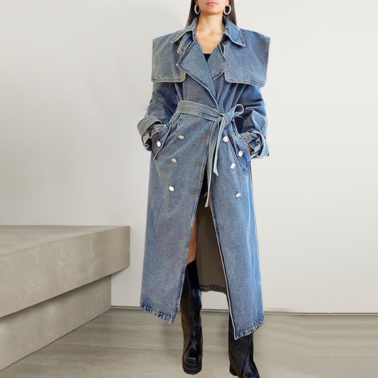Long denim coat with a belt worn by a person on a neutral background
