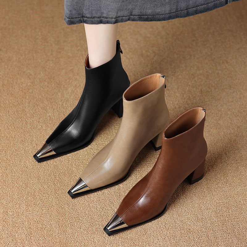 Three pairs of pointed-toe ankle boots in black, beige, and brown on a textured surface.