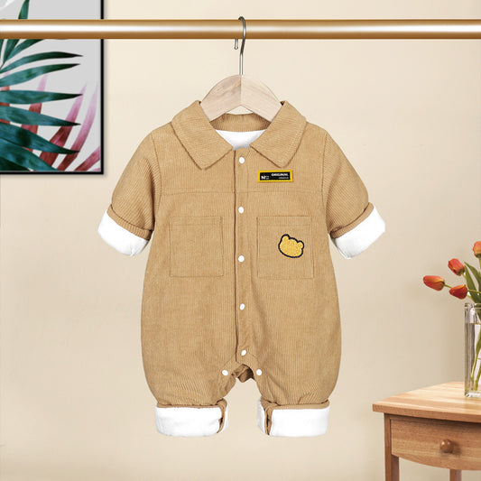 Beige baby romper with white sleeves and collar on a hanger against a beige wall.