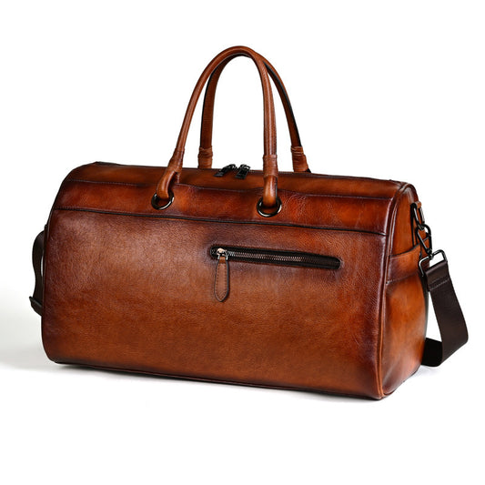 Brown leather duffel bag with a strap on a white background