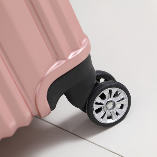 Close-up of a pink suitcase wheel on a light background